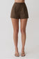 Woman wearing brown striped pintuck cotton shorts.