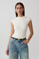 Woman wearing white peached jersey high neck top.
