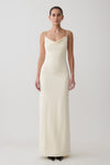 Woman wearing a white cowl maxi dress.