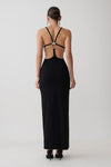 Woman wearing a crepe strapped back maxi dress with silver hardware.