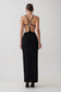 Woman wearing a crepe strapped back maxi dress with silver hardware.