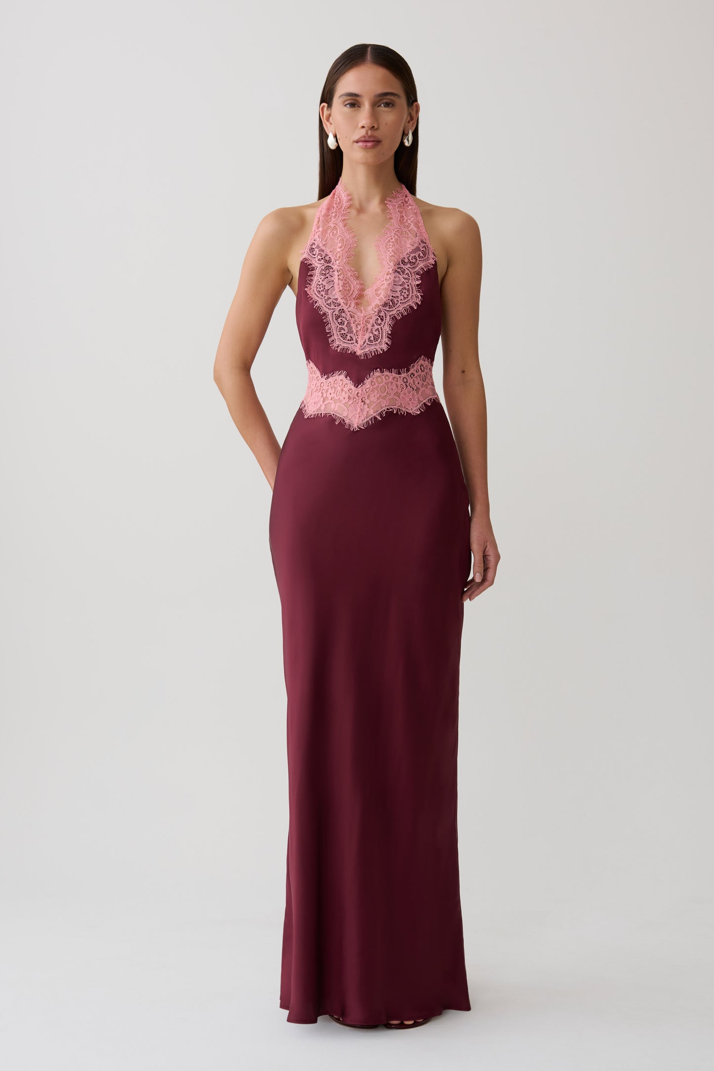 Woman wearing a burgundy satin and lace maxi dress.