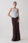 Woman wearing a light blue and dark brown lace and satin halter maxi dress.