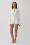 Woman wearing a white pointelle knit long sleeve top with matching shorts.