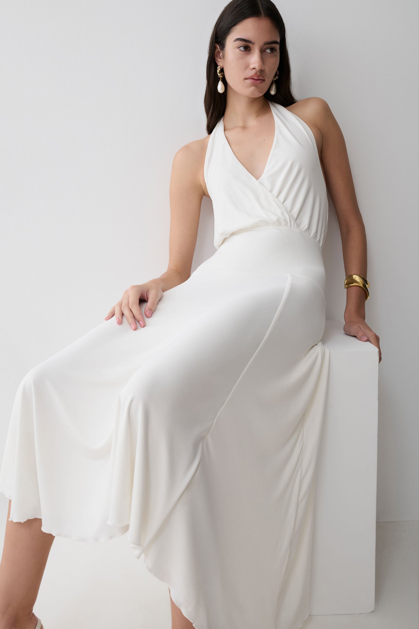 Woman wearing a white hankie halter midi dress.