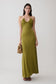 Woman wearing a green gathered slinky maxi dress.