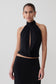Woman wearing a black sleeveless halter top.