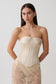 Woman wearing a gold satin strapless corset.