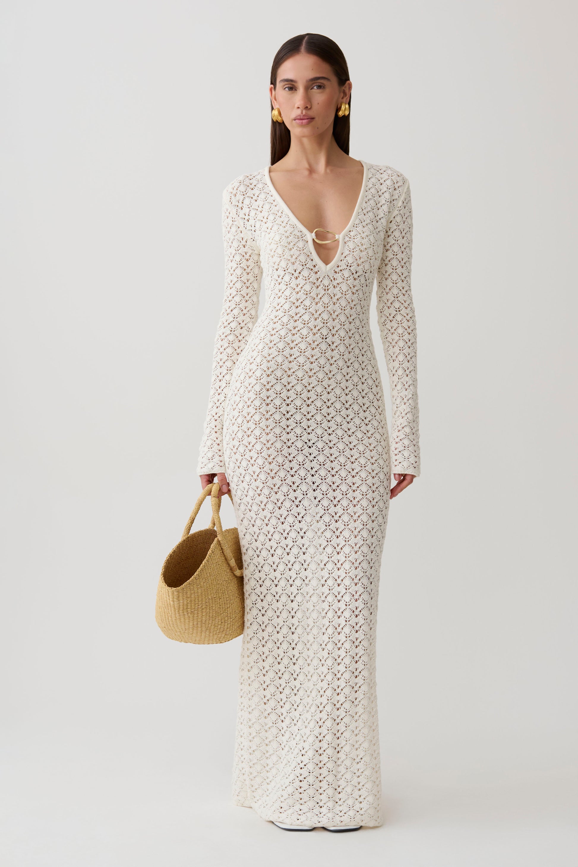 Woman wearing a white crochet knit maxi dress.