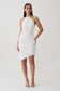 Woman wearing white draped hardware midi dress.