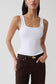 Woman wearing white square neck tank.