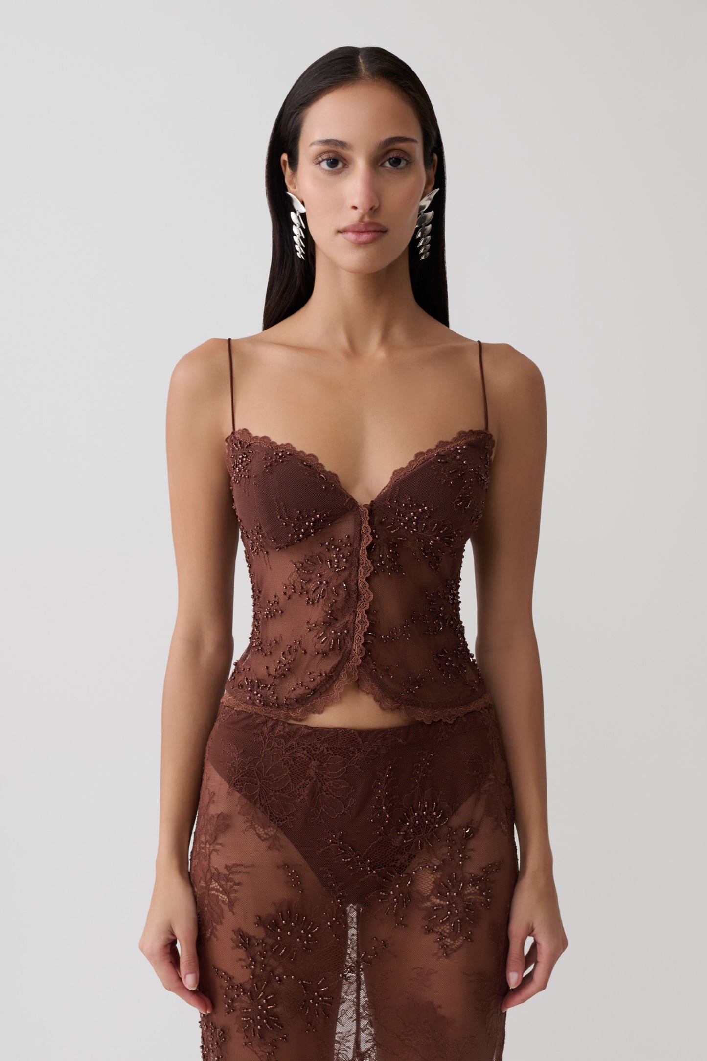 Woman wearing a brown sweetheart lace top.