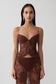Woman wearing a brown sweetheart lace top.