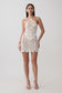 Woman wearing white crochet halter top with matching mini skirt.