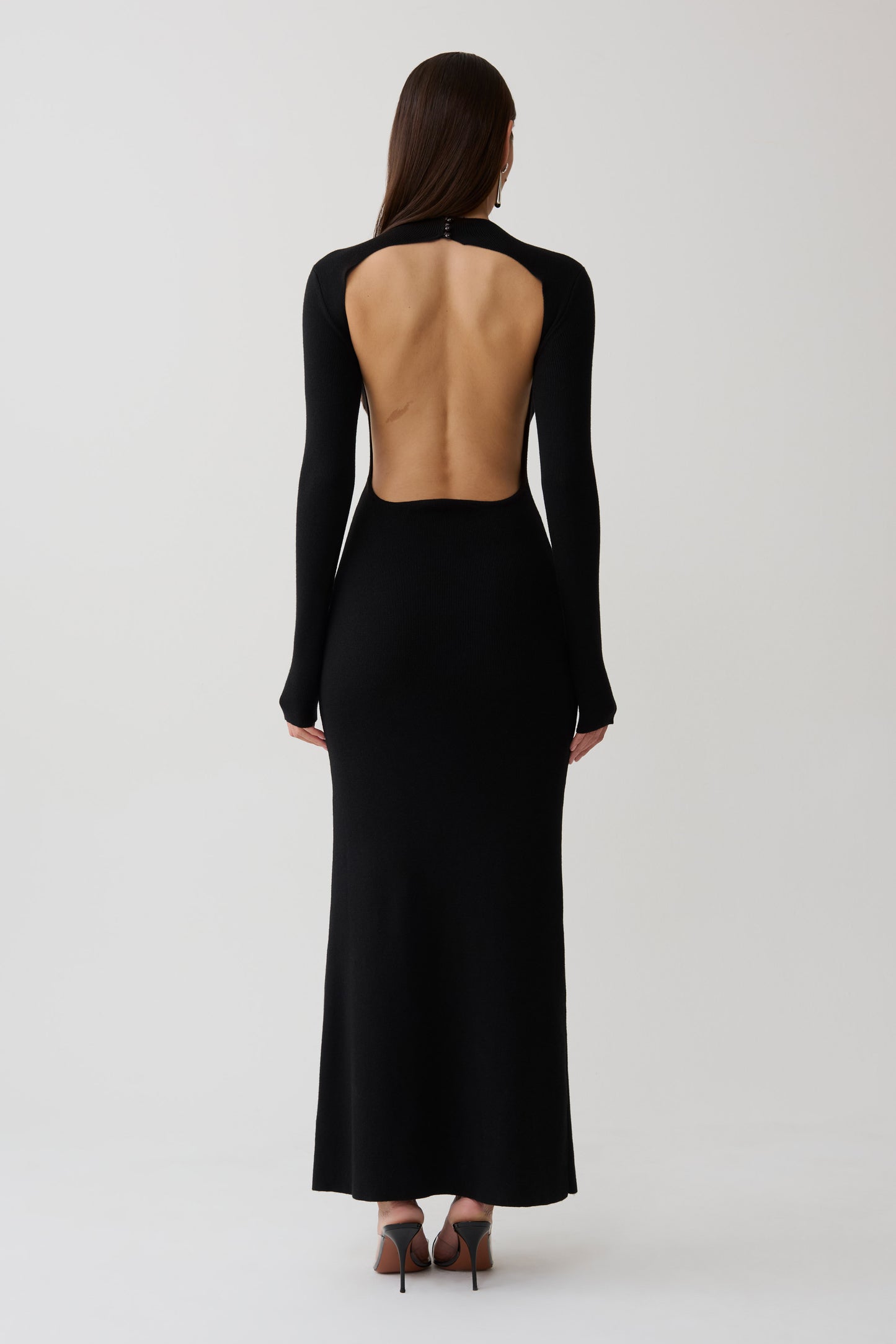 Woman wearing a black long sleeve knit maxi dress.