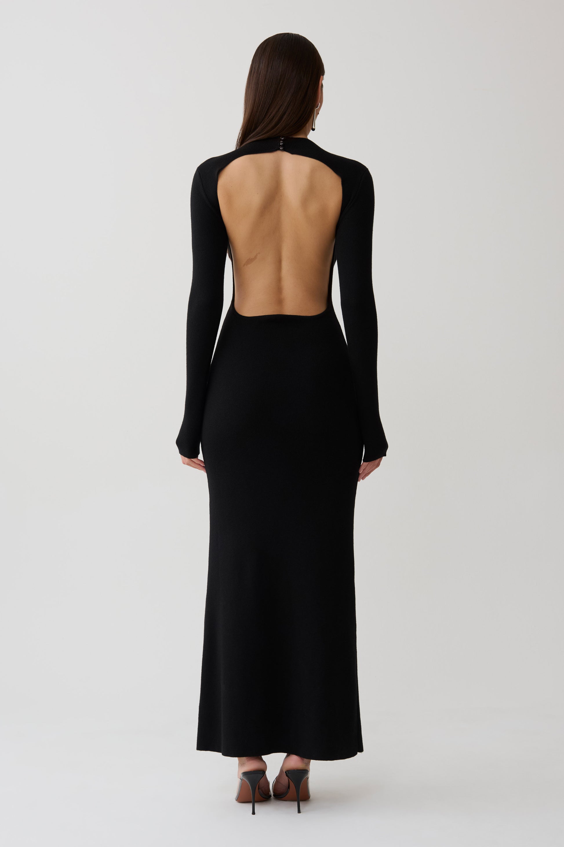 Woman wearing a black long sleeve knit maxi dress.