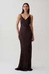 Woman wearing a dark brown v neck satin maxi dress.