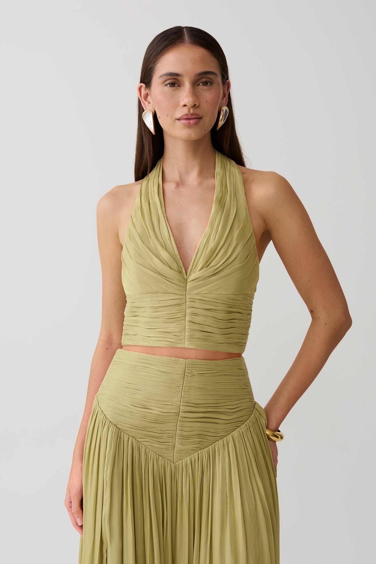 Woman wearing a green gathered v neck top.