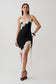 Woman wearing a black and white satin and lace mini dress.