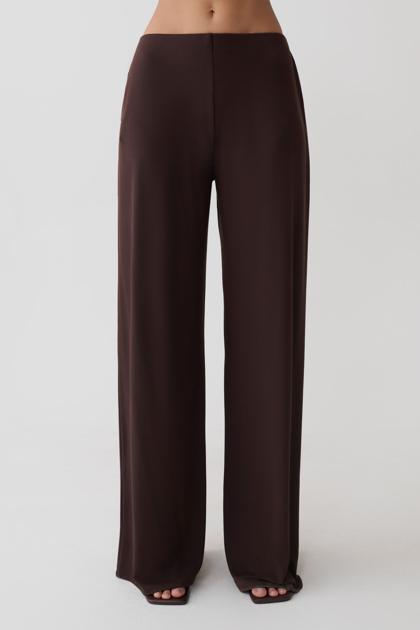 Woman wearing brown wide leg peached jersey pants.
