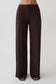 Woman wearing brown wide leg peached jersey pants.