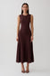Woman wearing a brown pleated midi dress.