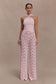 Woman wearing a pink knit top and crochet pants.