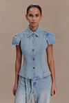 Woman wearing a collared short sleeve denim top.