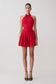 Red halter dress worn by a model on a light gray background