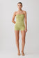 Woman wearing a green strapless top and shorts with gold hardware.