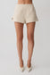 Woman wearing beige linen shorts.