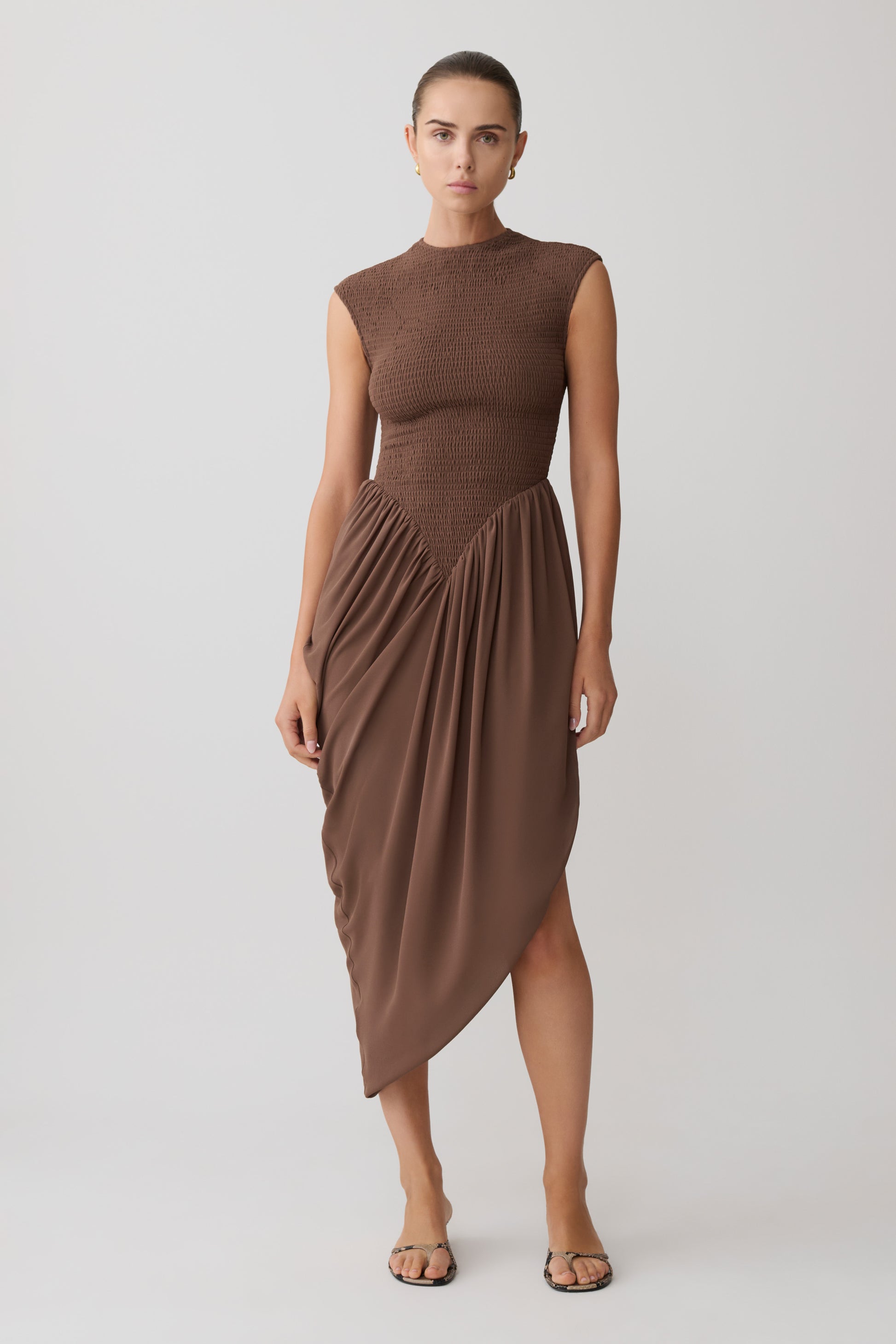 Woman wearing a brown shirred mini sleeveless dress.