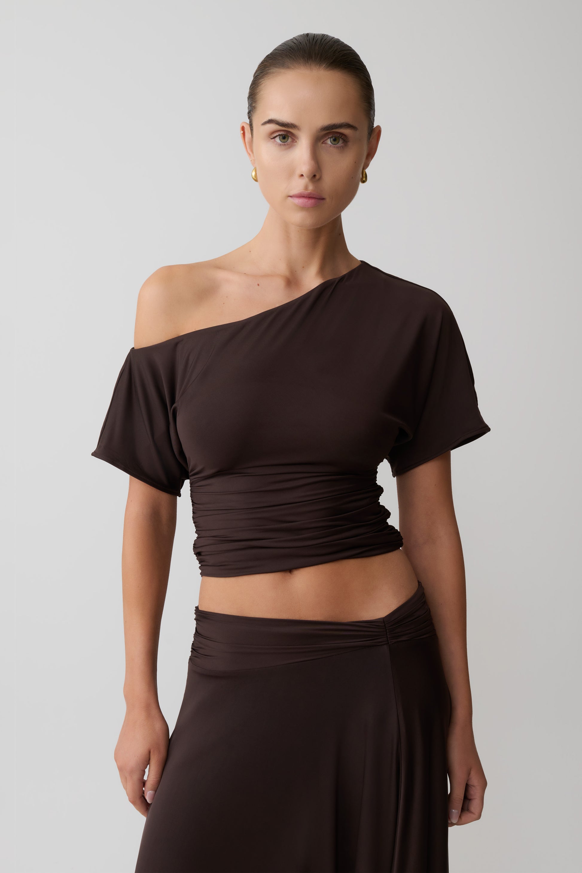 Woman wearing a brown off-shoulder top.