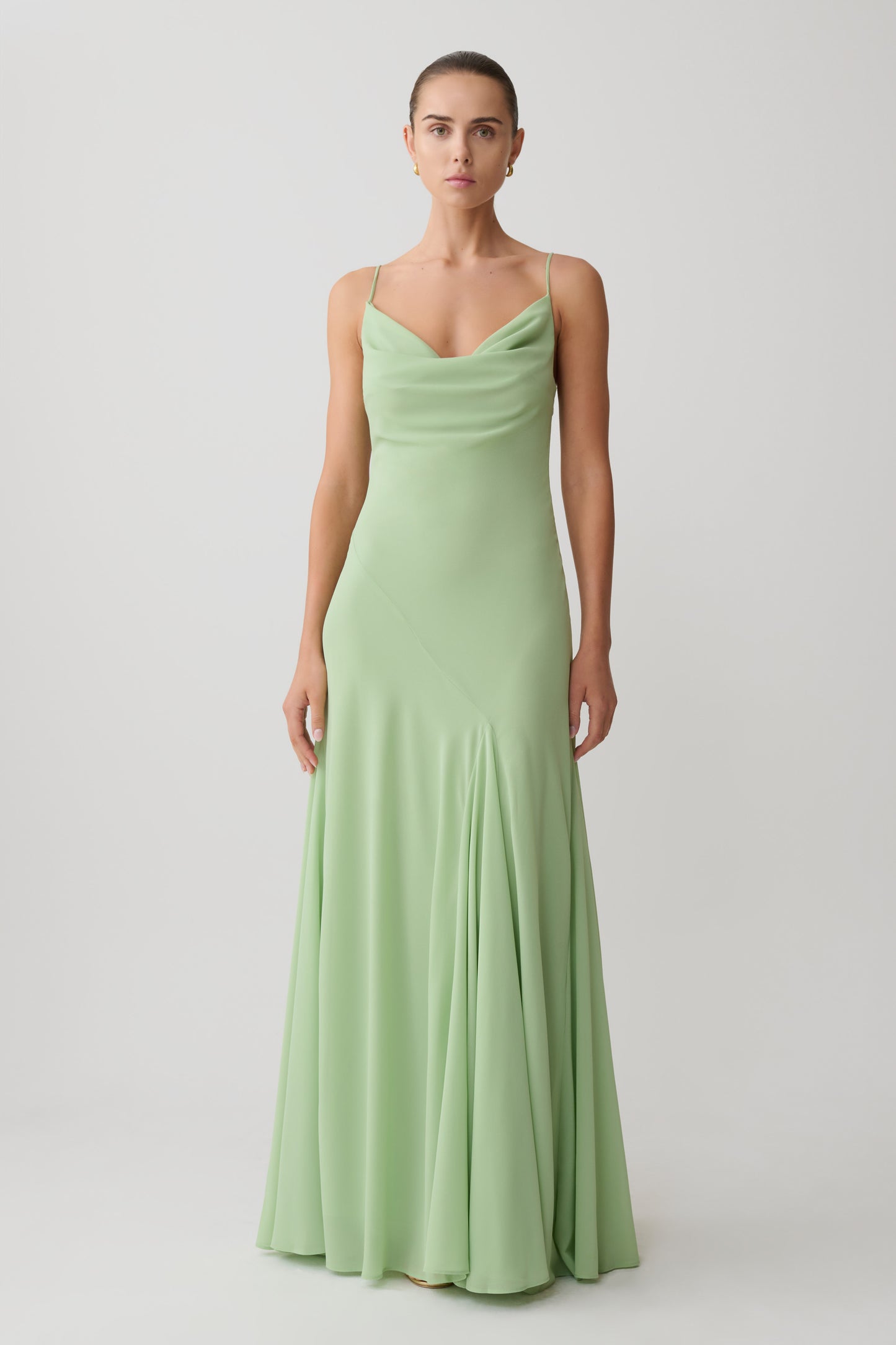 Woman wearing a light green chiffon maxi dress.