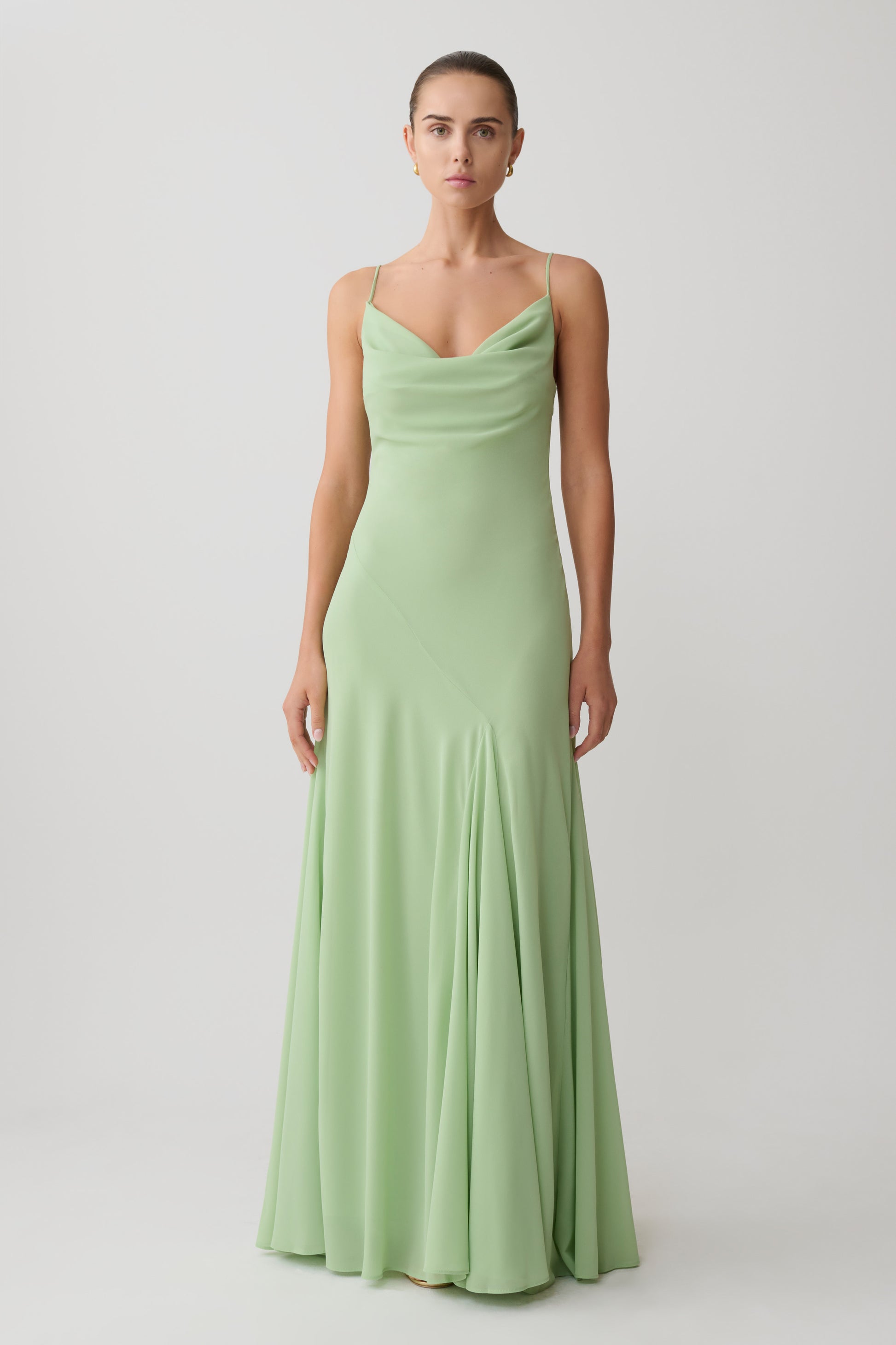 Woman wearing a light green chiffon maxi dress.