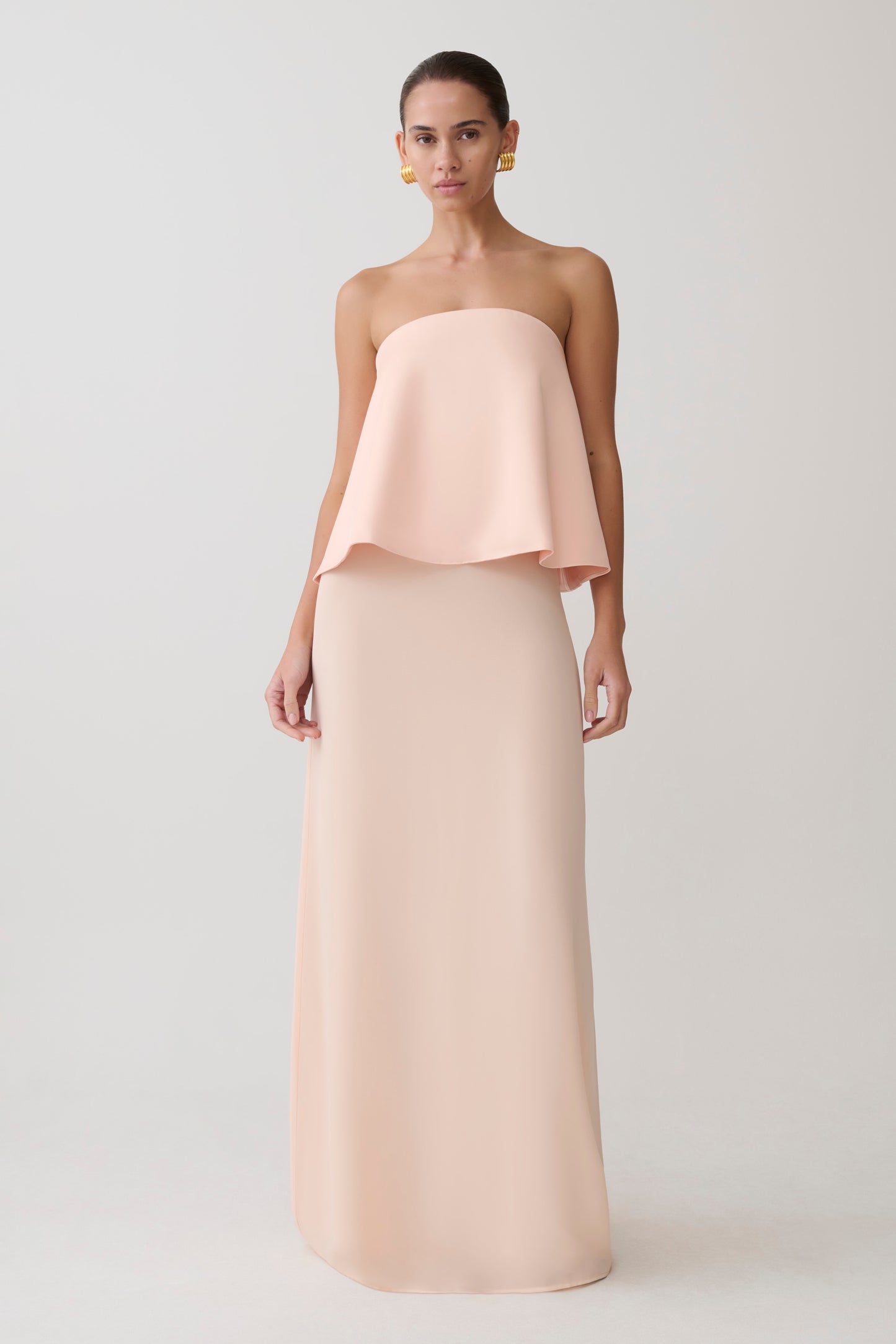 Woman wearing a strapless blush pink gown.