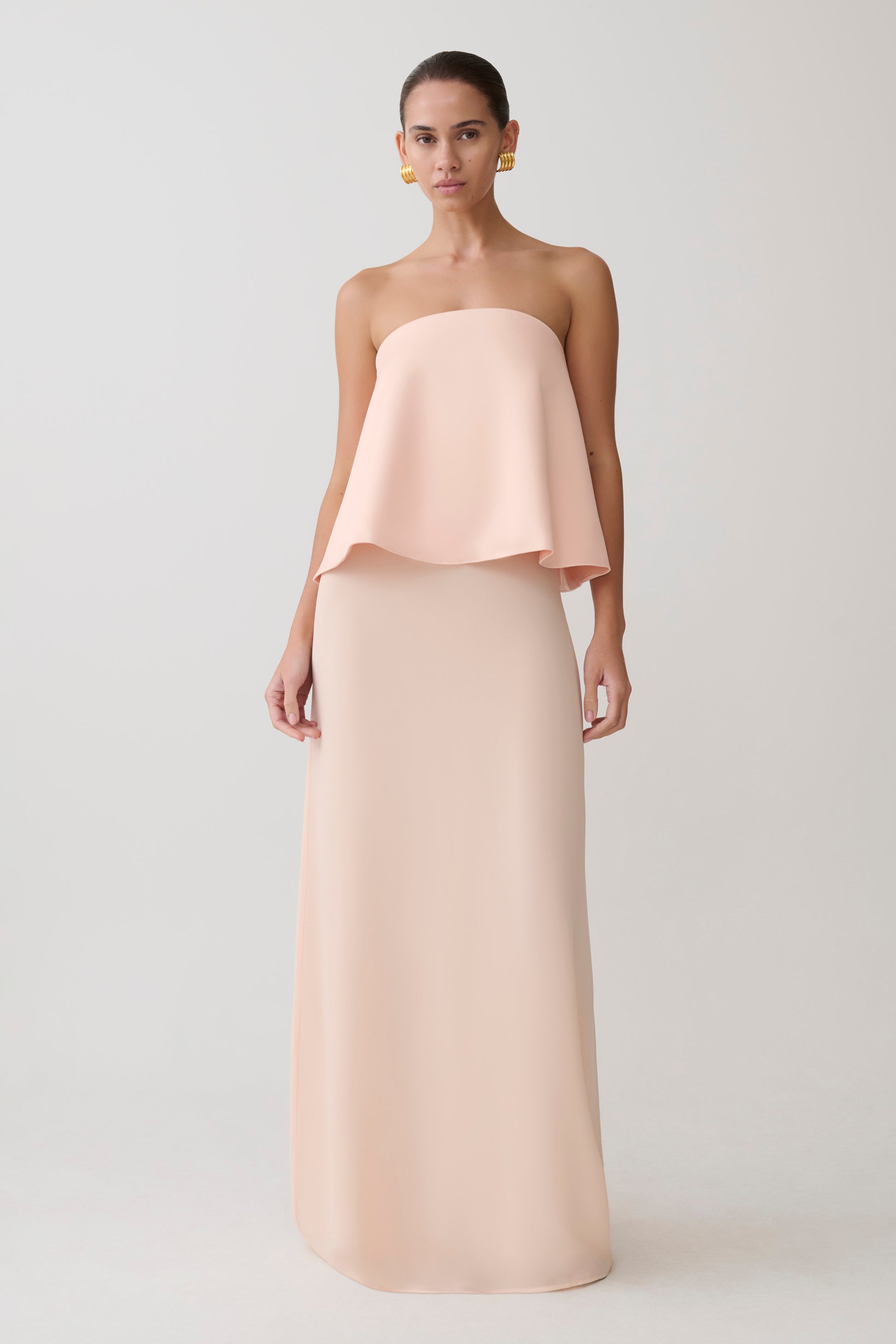 Woman wearing a strapless blush pink gown.