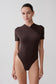 Woman wearing a brown bodysuit.