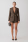 Woman wearing a brown blazer with gold hardware and matching shorts.