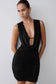 Woman wearing a black dress with a plunging neckline.