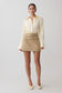 Woman wearing a cream blouse and beige skirt on a white background