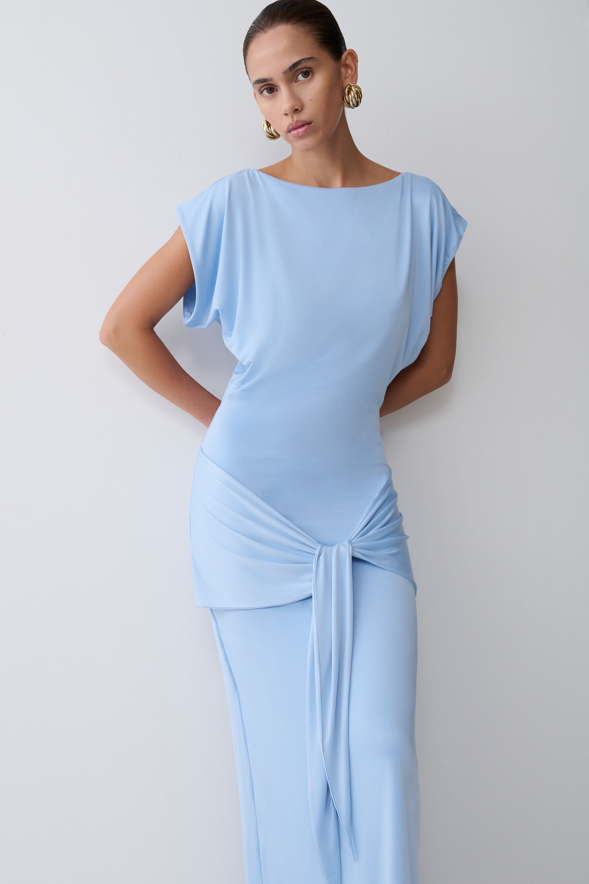 Woman wearing a light blue dress against a plain background
