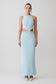 Woman wearing a light blue evening gown with lace details on a white background