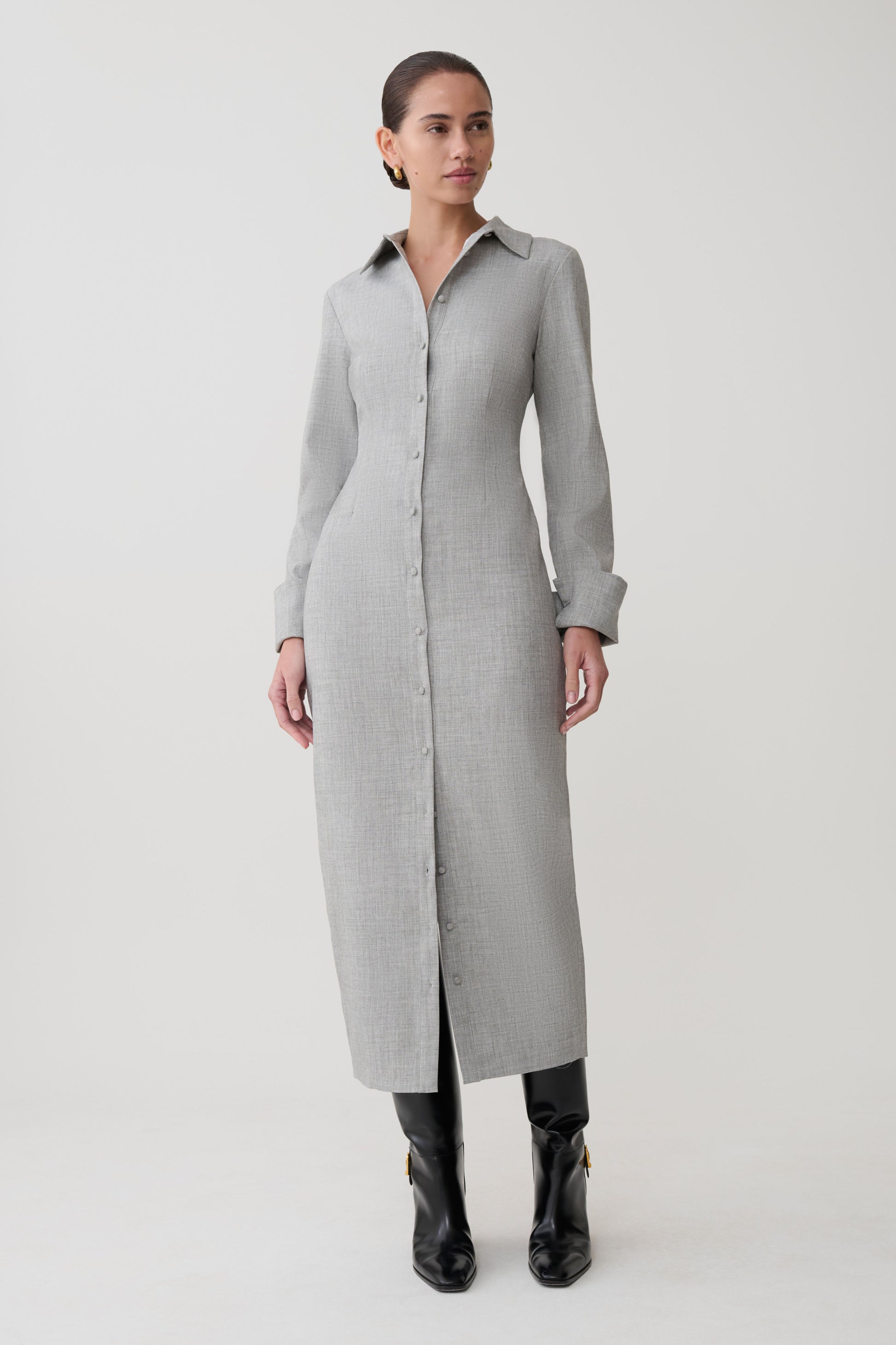 Woman wearing a long gray coat on a white background