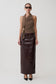 Woman wearing a brown top and dark brown leather skirt on a white background