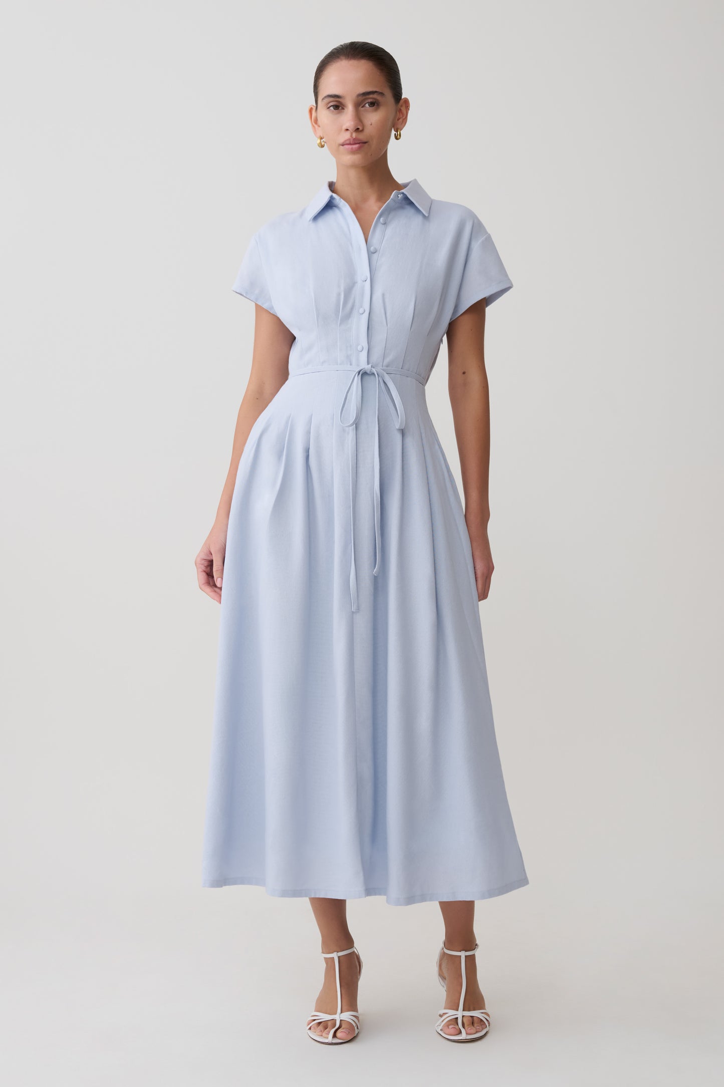 Woman wearing a light blue dress with a white background