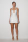 Woman wearing a white sequin dress on a plain background