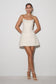 Woman wearing a white strapless dress against a plain background