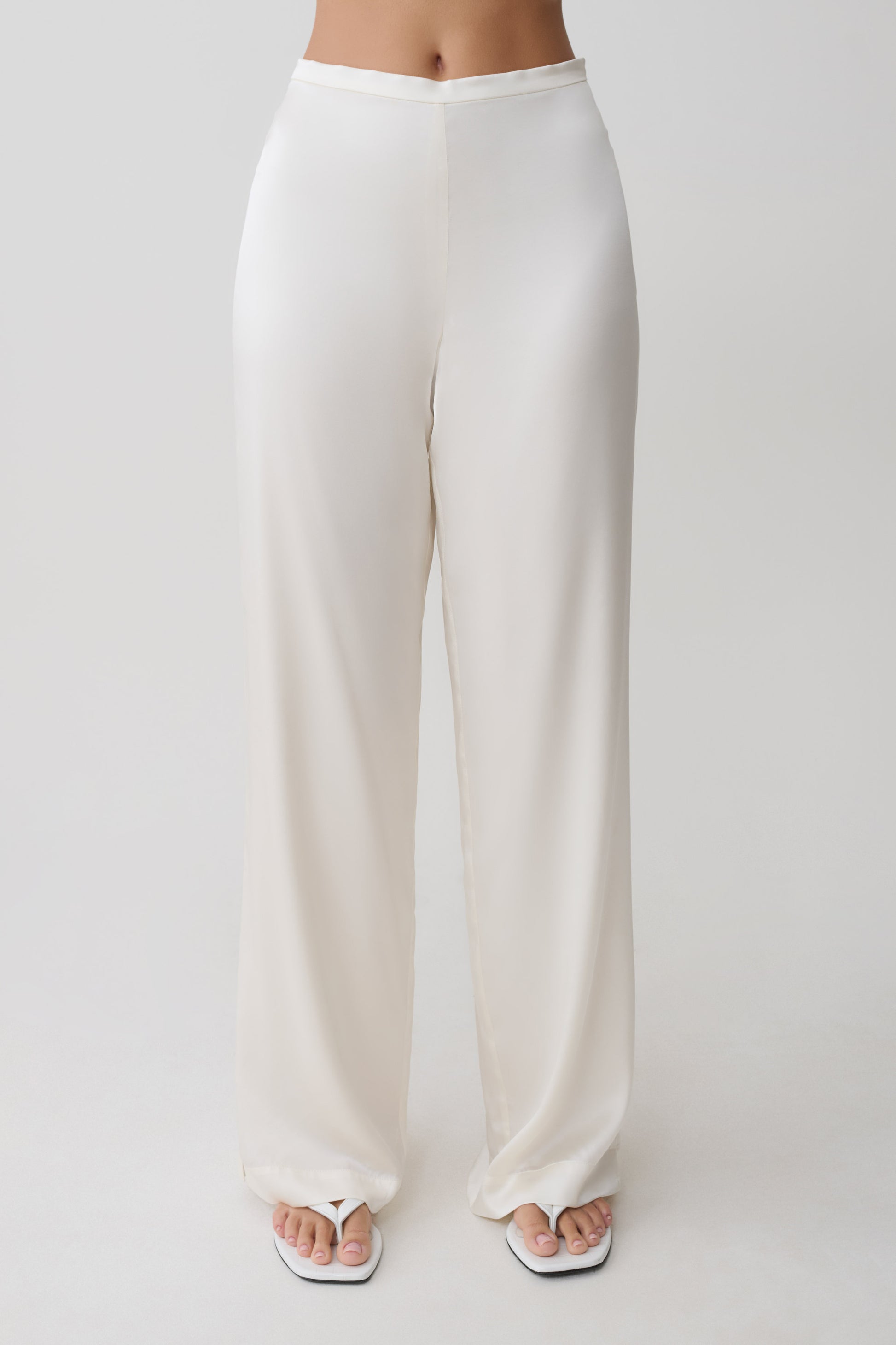 Woman wearing white silk blend pants.