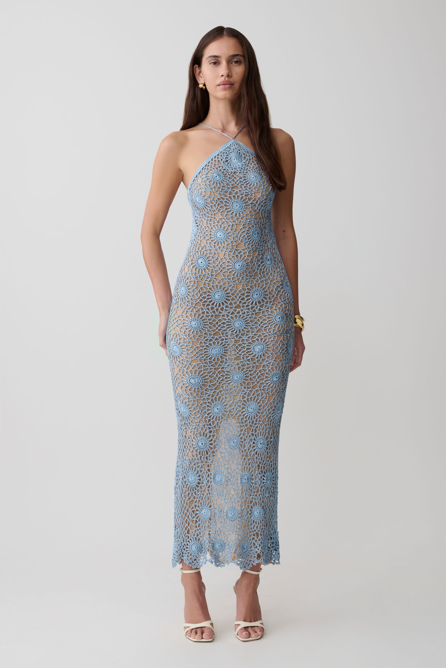 Woman wearing a periwinkle halter hand crochet maxi dress.